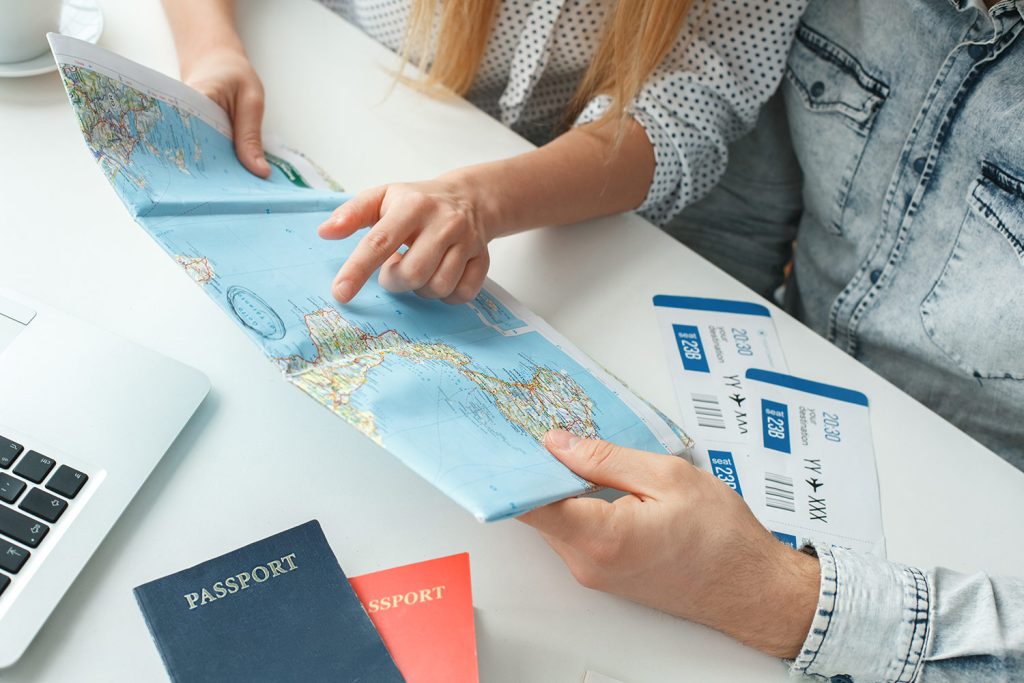 image showing tourists pointing on world map for their next tour